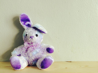 cute rabbit doll with wooden background and space copy