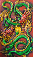 Fototapeta premium close up of the green dragon's fight on the red wall.