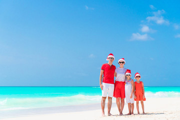 Happy family in Santa Hats during tropical Christmas vacation
