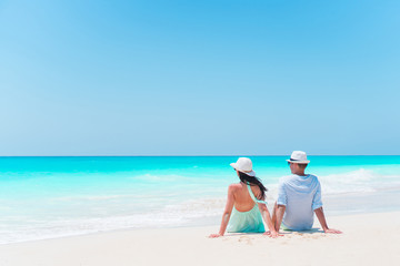 Fototapeta na wymiar Young couple on white beach during summer vacation. Happy lovers enjoy their honeymoon. Family beach vacation