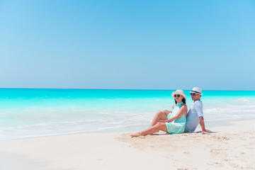 Young couple on white beach during summer vacation. Happy lovers enjoy their honeymoon
