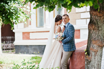 Naklejka premium Flawless wedding young couple walking on city streets on a sunny day.