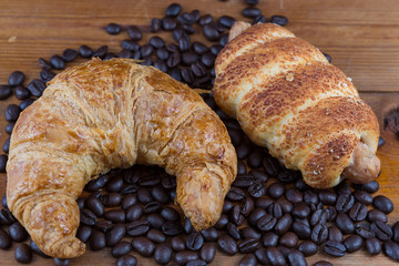 croissant, sausage dough and coffee beans on wooden table