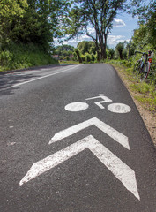 Obraz premium white painted signpost for cyclists on the road