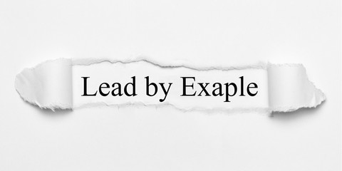 Lead by Exaple on white torn paper