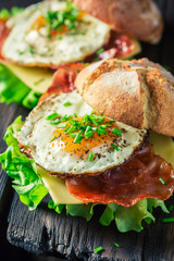 Closeup of burger with lettuce, bacon and eggs