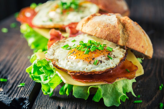 Closeup of delicious burger with lettuce, bacon and eggs