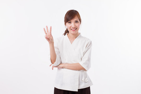 woman spa therapist pointing up 3 fingers, counting, numbering