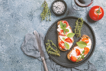 Crostini appetizers with cherry tomatoes, and cheese