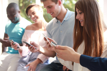 Group of students watching smartphones. Young people addiction to new technology trends.