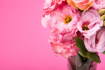 Close-up view of beautiful tender pink eustoma flowers bouquet in vase isolated on pink