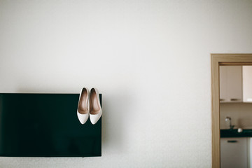 Bride wedding shoes with high heels and silver brilliant earrings on sheep's clothing