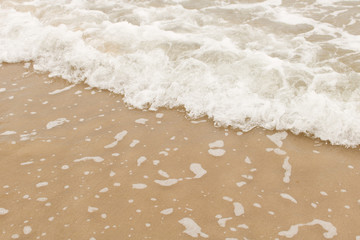 Wave of the sea on the sandy beach.