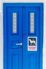 A traditional  door on the cyclades islands with beware of the dog