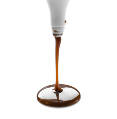 Delicious chocolate sauce flowing onto white background