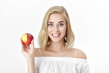 Portrait of blond woman with white teeth eating fresh nectarine. female smile