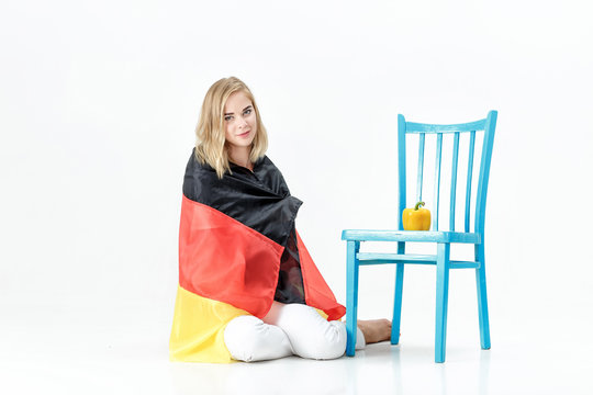 Beautiful blond woman with flag of Germany and vegetables. Export and import of vegetables