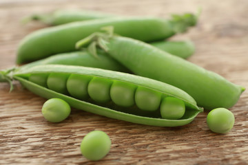 Fresh green peas on wooden background