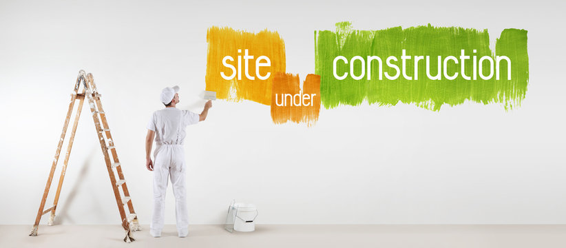 painter man with paint brush drawing under construction text isolated on the blank white wall