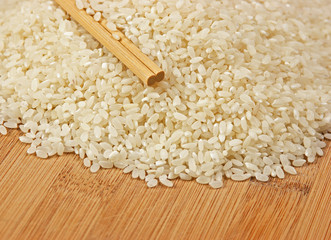 raw rice and chopsticks on bamboo board