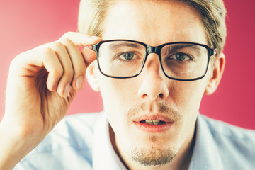 Surprised businessman staring through glasses