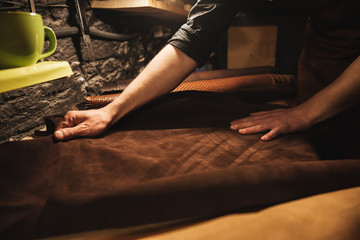 Young man shoemaker at footwear workshop.