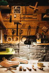 Ynstruments on wooden wall at footwear workshop.