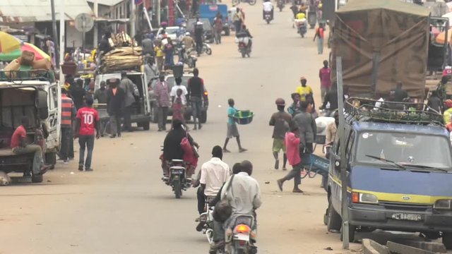 Market village town centre in Guinea West Africa with traffic and people walking