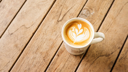 Hot latte coffee on a wooden table.
