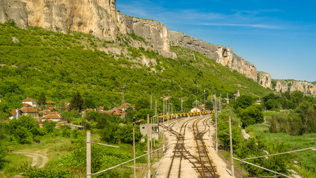 The railway station of the village  the Kunino In the background the Rock Wreaths red rock ( chervenica ) , municipality of Roman, Vratsa district. Northwestern Bulgaria