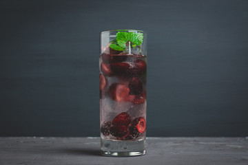 Cherries mojito on the wooden background. Selective focus.