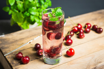 Cherries mojito on the wooden background. Selective focus.