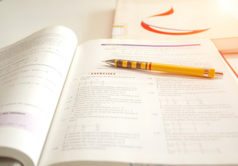 Closeup Exercises Solving Exponential Equations,Closeup of a page of calculus book with integrals and trigonometric functions with yellow pencil.