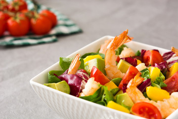 Shrimps salad with mango and avocado on gray stone
