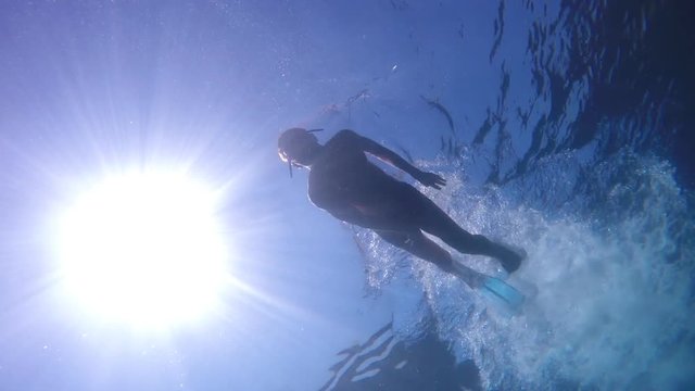 Swimmer in flippers dives into the sea, raw, 4K