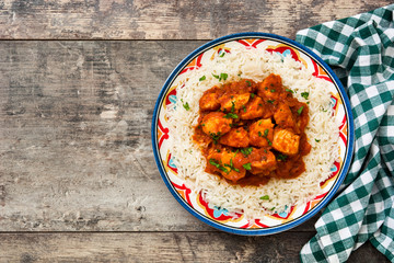 Chicken tikka masala with basmati rice on wooden table.Top view

