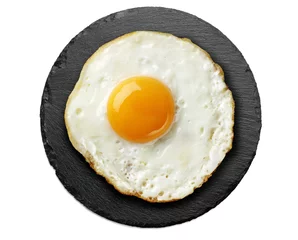 Keuken foto achterwand Spiegeleieren gebakken ei op ronde zwarte leisteen