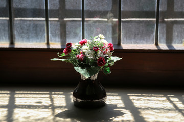 Flowers in a glass vase on a windowsill