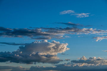 Obraz premium bright blue sky , puffy white clouds, sunset 