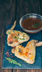 Grilled chicken wings with barbecue sause on black background 
