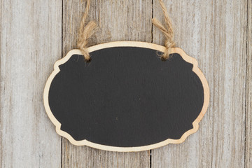 Hanging oval chalkboard on weathered wood wall