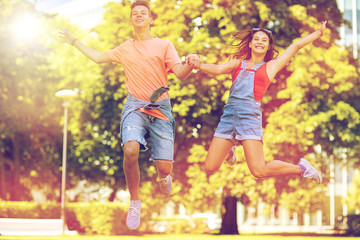 Fototapeta premium happy teenage couple jumping at summer park