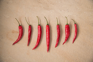 Mediterranean looking Red Chilli Peppers on sandstone background