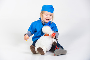 child in doctor uniform playing vet with toy animal