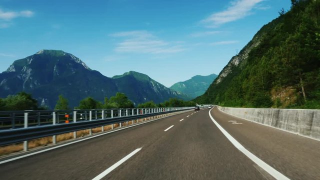 The magnificent highway in Austria, in the background beautiful Alps. Quickly ride along the asphalt road
