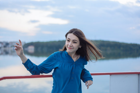 Summer happy portrait beautiful woman girl caucasian asian blended in blue shirt posing on background sky lake water sunset long hair brunette outdoors