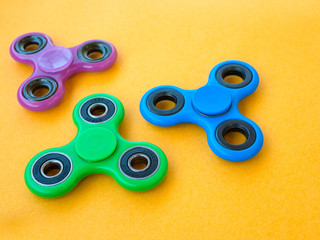 Popular colourful fidget spinner toy on a colored background