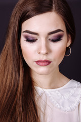 Fototapeta premium Studio portrait of a beautiful young woman with brown hair. Pretty model girl with perfect fresh clean skin. Beauty and skin care concept