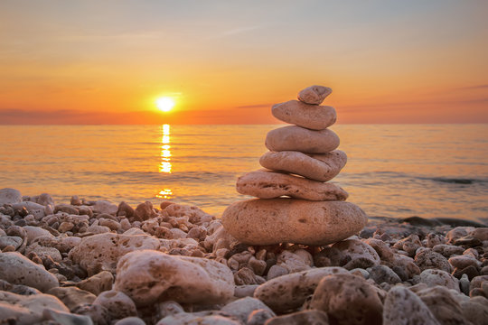 Pyramid of stones on the beach, beautiful sunset, sea landscape