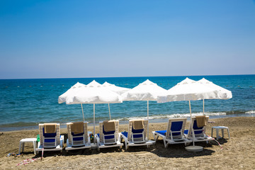 beach chairs and umbrellas on sand beach